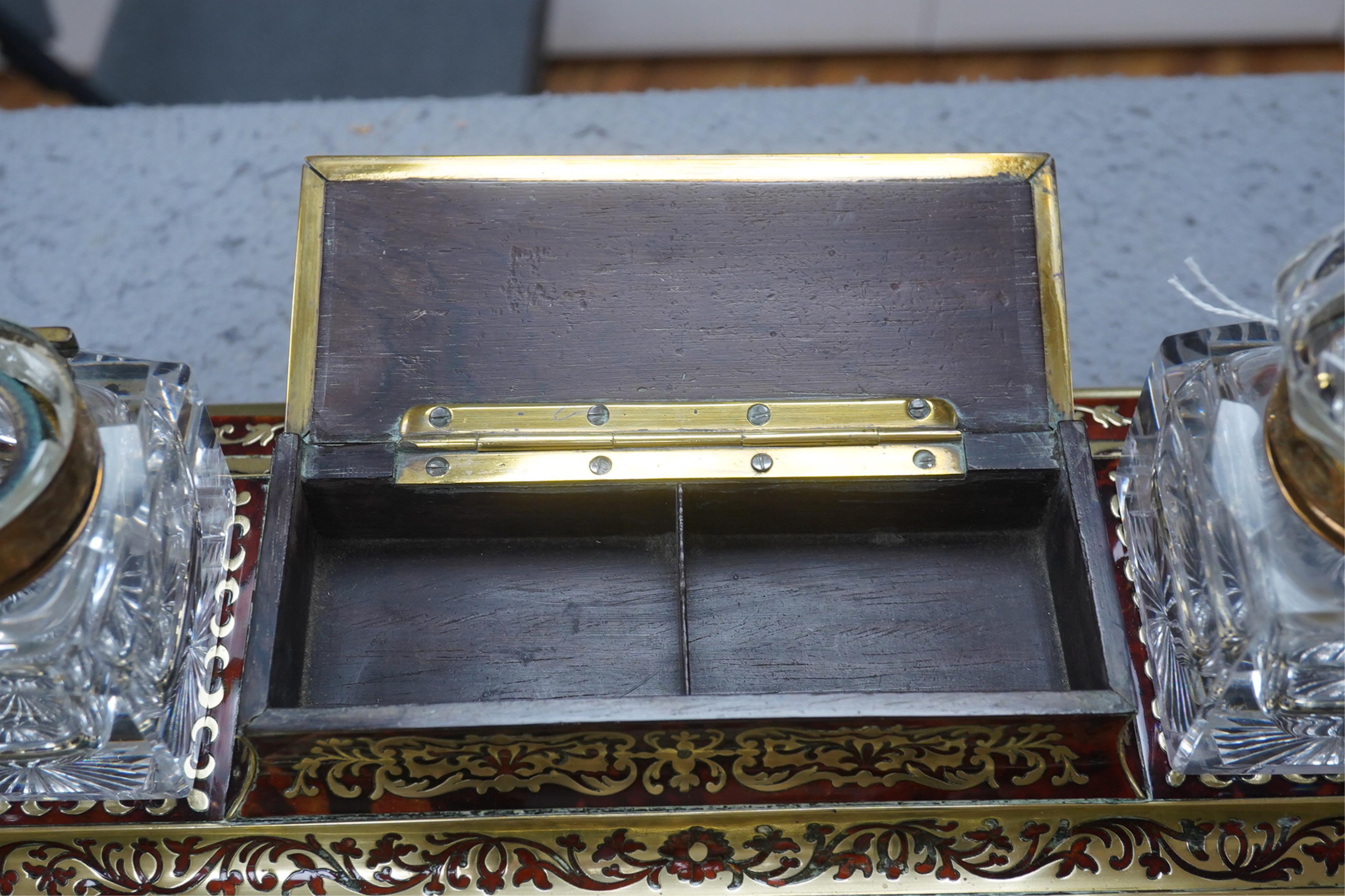 A French scarlet boullework double inkstand with original glass ink bottles c.1850, 39cm wide. Condition - inkstand good, one inkwell cover missing